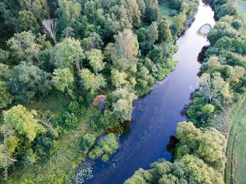 A beautiful sunny view of the forest, fields and river from above. Summer drone photography 