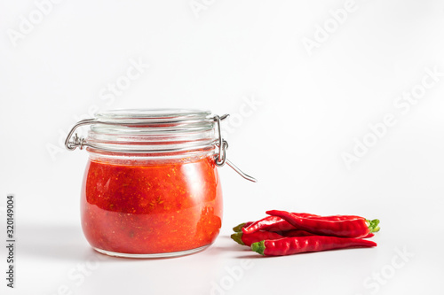 Hot chili pepper sauce paste harissa. Adjika. Traditional Tunisia, Georgian and Arabic cuisine. Homemade rose harissa in a glass jar. photo