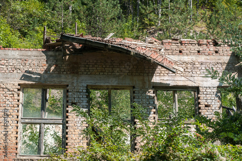 Old obsolete industrial building facade with broken windows © varbenov