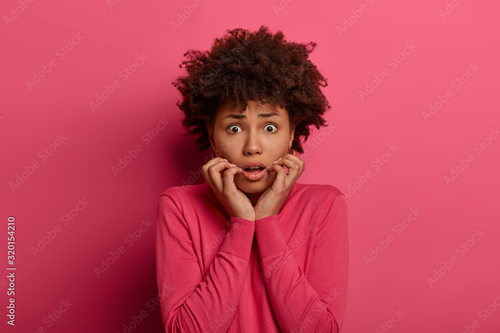 Anxious vexed woman looks with panic and worry, keeps hands near opened mouth, trembles nervously, has terrified expression, scared of something, faces big life problems, makes awful mistake Anxious vexed woman looks with panic and worry, keeps hands near opened mouth, trembles nervously, has terrified expression, scared of something, faces big life problems, makes awful mistake