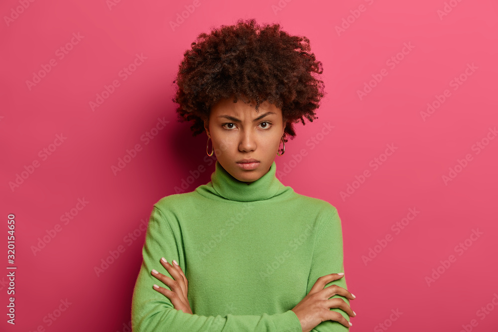 Serious looking offended woman looks angrily at camera, keeps arms folded, smirks face, doesnt trust person, dressed casually, isolated on pink wall, dislikes suspicious idea, disagrees with someone Serious looking offended woman looks angrily at camera, keeps arms folded, smirks face, doesnt trust person, dressed casually, isolated on pink wall, dislikes suspicious idea, disagrees with someone