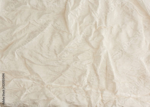 crumpled beige synthetic fabric for the manufacture of lining for skirts