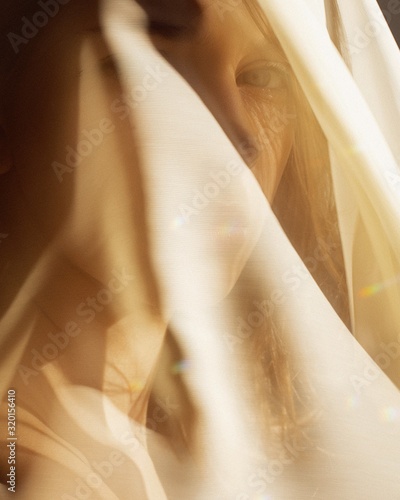  Oriental portrait in the rays of the setting sun through the veil