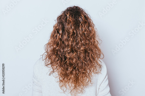 Rear view woman's head with beautiful long naturally curly hair
