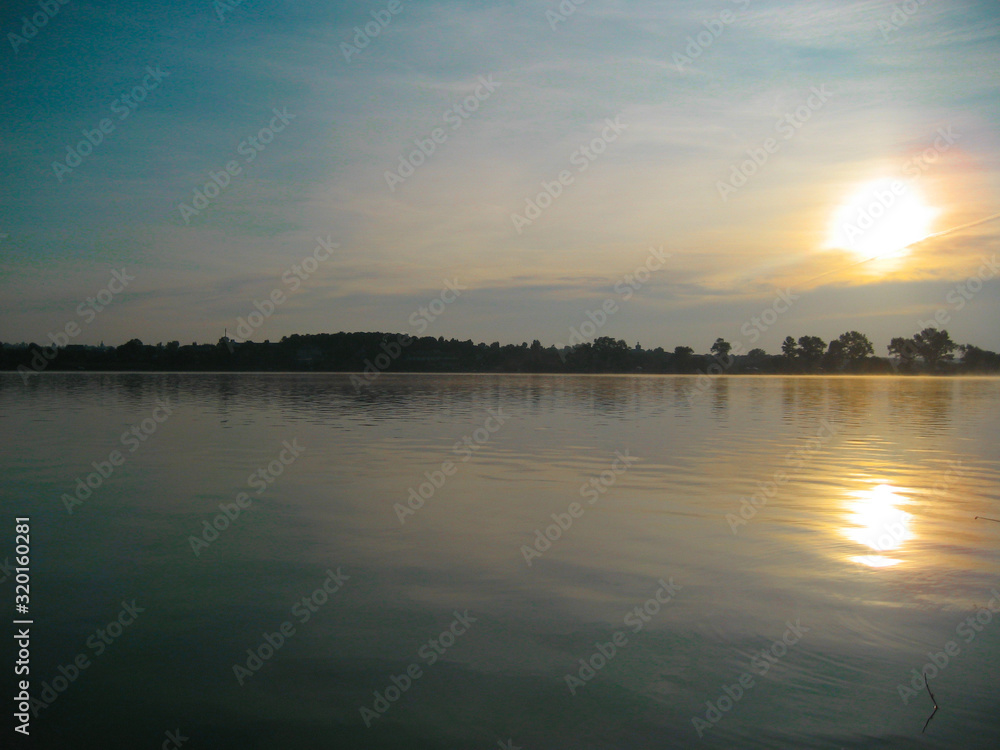 Majestic sunset over the lake in twilight sky background. Nature background in the Panoramic sunset sky background. Summer landscape.