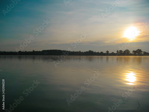 Majestic sunset over the lake in twilight sky background. Nature background in the Panoramic sunset sky background. Summer landscape.