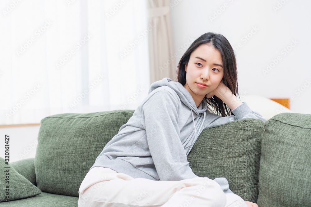 リビングのソファーに座る女性 リビングのソファーに座る女性