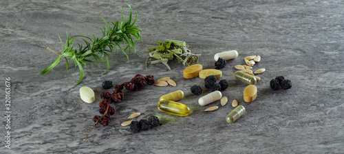 drugs pills food suplements healthy medicine medication health care treatment additives pharmacy pharmaceutical industry at grey background WITH GREEN PLANTS photo