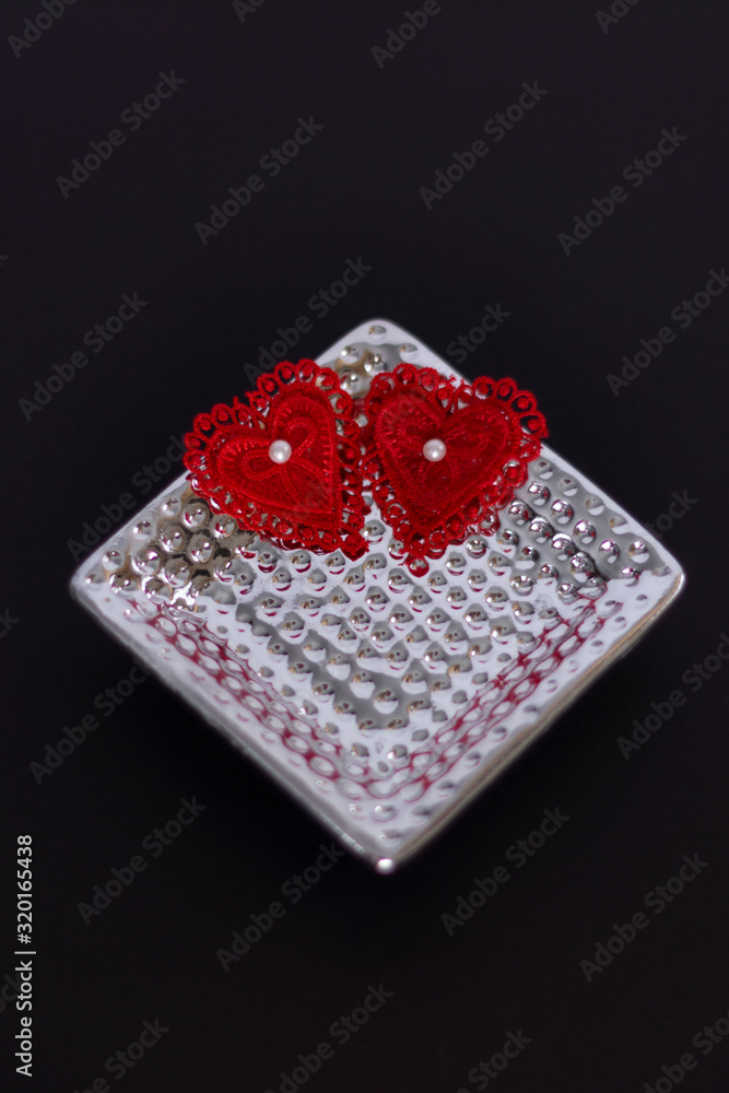 Red lace hearts white pearls silver dish black background valentines