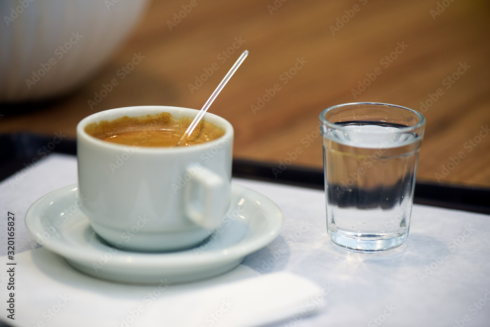 Closeup of espresso cup with glass of water Closeup of espresso cup with glass of water