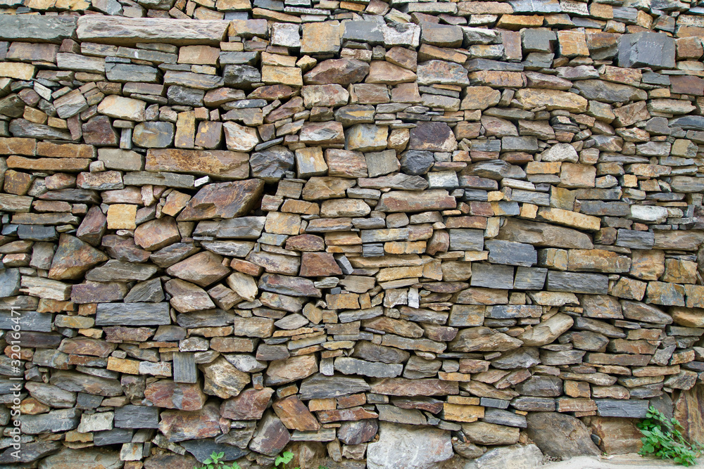Fototapeta premium Wall of small natural stones