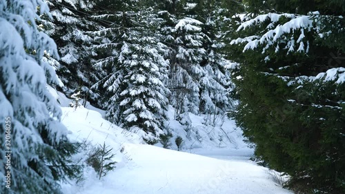 Unrecognizable skiers going up the hill in the forest on a chair lift
