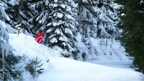 Unrecognizable skiers going up the hill in the forest on a chair lift