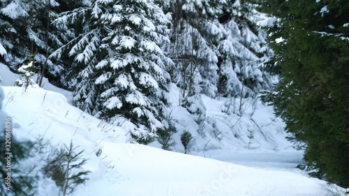 Unrecognizable skiers going up the hill in the forest on a chair lift