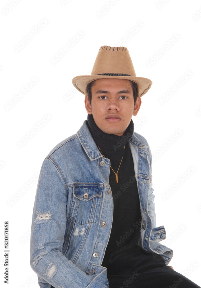 Young tall man sitting wearing a cowboy hat Young tall man sitting wearing a cowboy hat