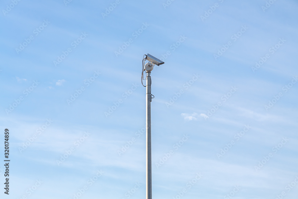 Security camera at day with blue sky in background