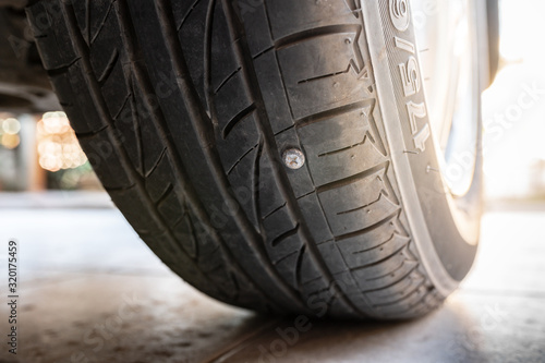 Close-up nail or screw stick on the car tire, the most problem of flat tire
