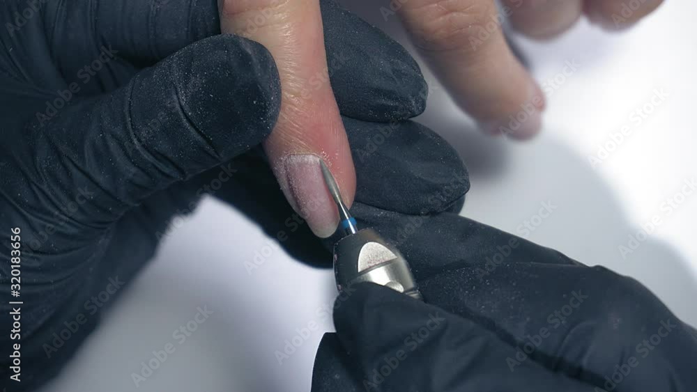 Manicure master doing manicure for client with a Electric Nail File Drill Machine. Hardware manicure. Manicure master doing manicure for client with a Electric Nail File Drill Machine. Hardware manicure.