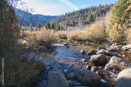 Fototapet bishop creek flowing through forested hills and mountains
