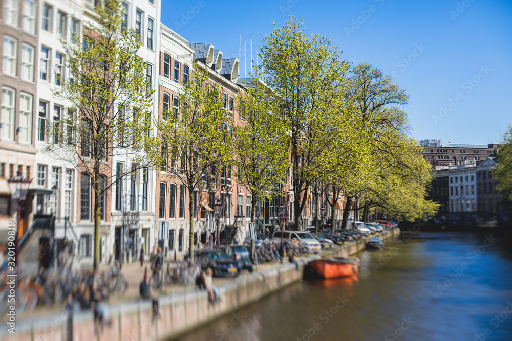 View of Amsterdam street in the historical center, with canal houses in the capital city of Amsterdam, North Holland, Netherlands, summer sunny day