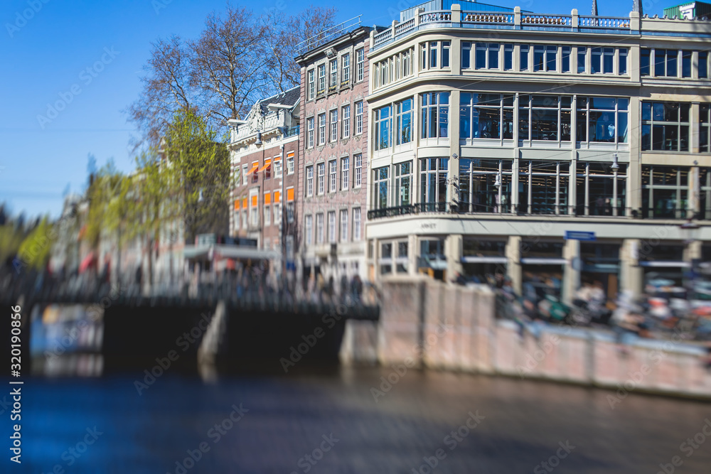 Naklejka premium View of Amsterdam street in the historical center, with canal houses in the capital city of Amsterdam, North Holland, Netherlands, summer sunny day