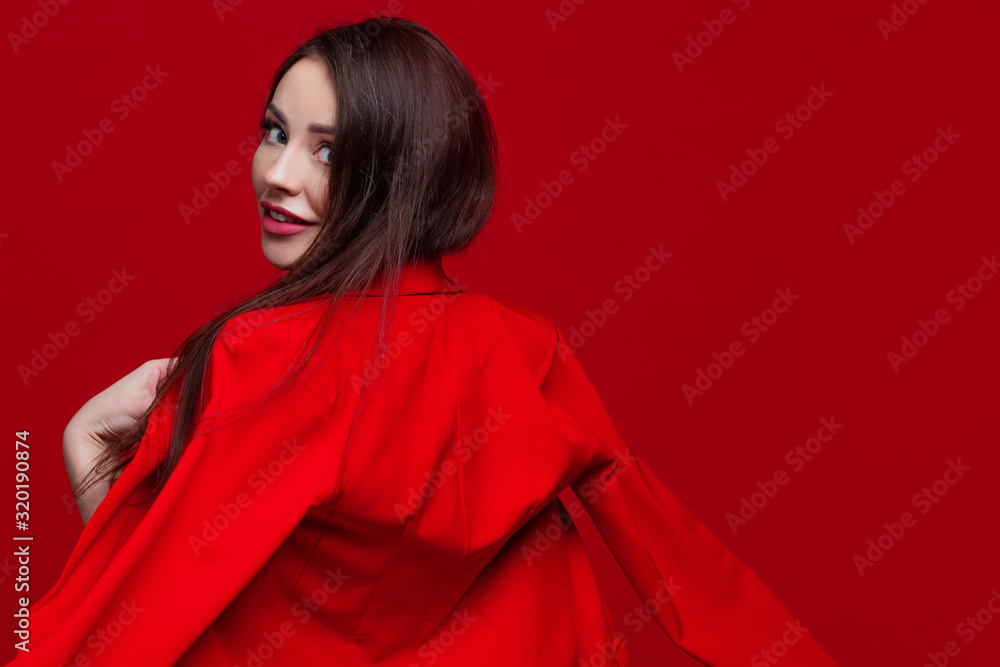 Bright and beautiful girl in a red pantsuit on a red background Bright and beautiful girl in a red pantsuit on a red background
