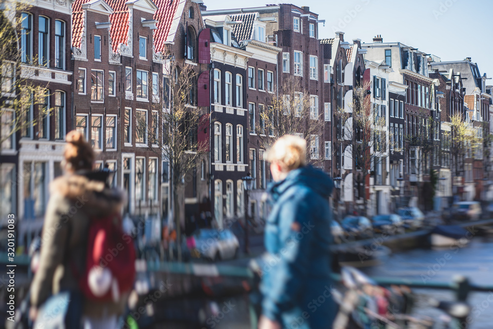 Obraz premium View of Amsterdam street in the historical center, with canal houses in the capital city of Amsterdam, North Holland, Netherlands, summer sunny day