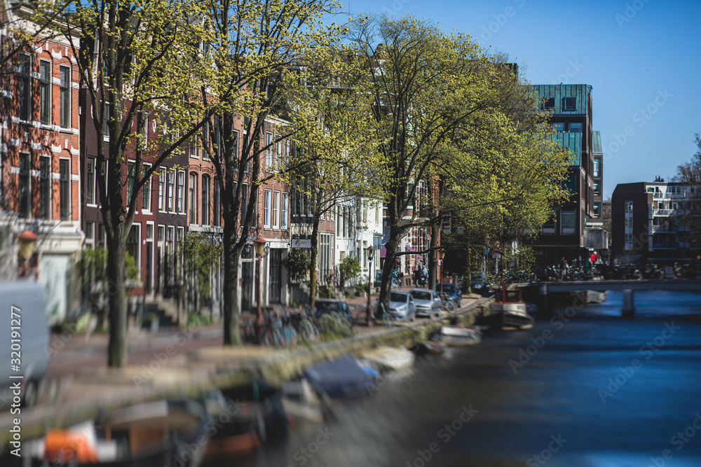 Fototapeta premium View of Amsterdam street in the historical center, with canal houses in the capital city of Amsterdam, North Holland, Netherlands, summer sunny day