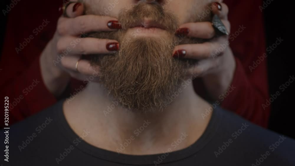 Hands of woman massaging man's beard, slow motion, shallow depth of field Hands of woman massaging man's beard, slow motion, shallow depth of field