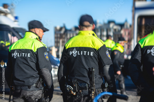 Dutch police squad formation and horseback riding mounted police back view with 