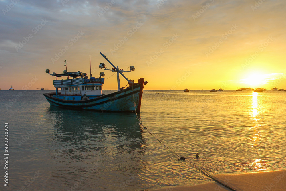 Fishing boat on a deserted beach on sunset background Fishing boat on a deserted beach on sunset background