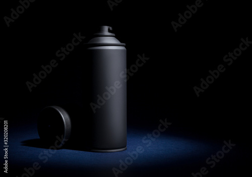 Spray can with spray paint on a black background