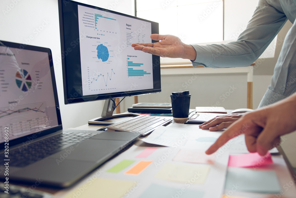 Φωτογραφία Businessman point to the graph of the company financial statements in the paperwork and together analyzing the work room