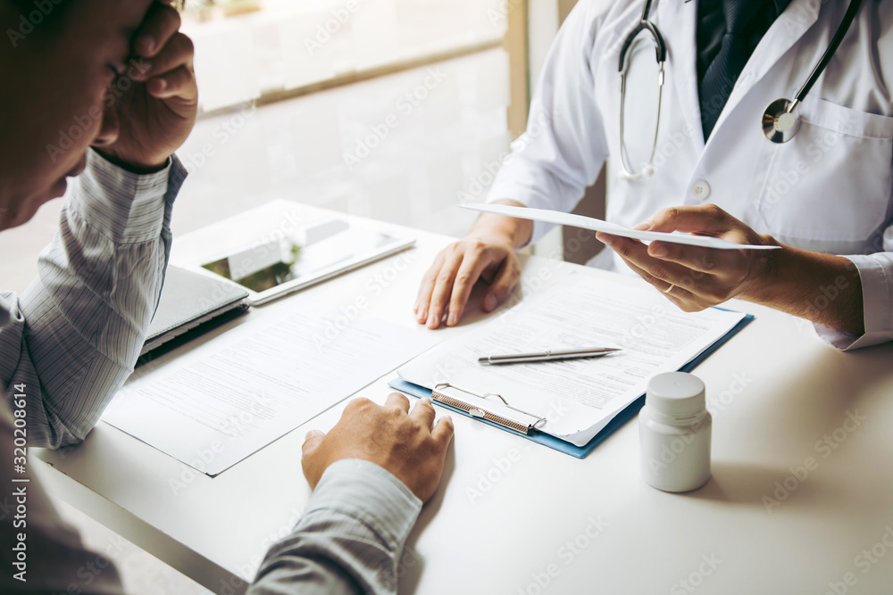 Φωτογραφία Asian male doctor talking in clinic room and handing a prescription to the patient