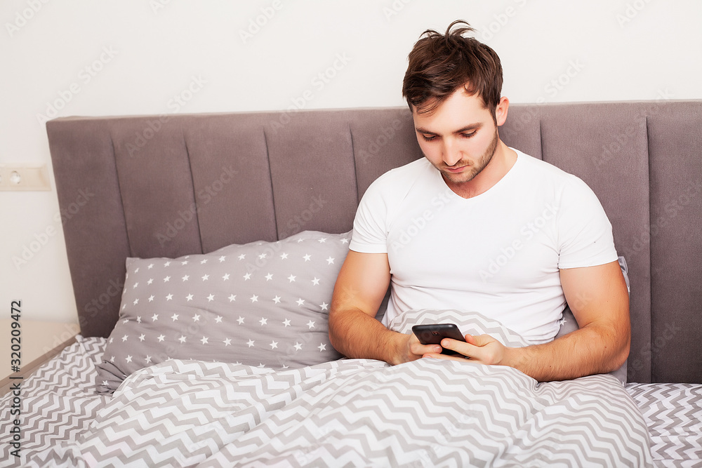Man addicted to his mobile phone in bed Man addicted to his mobile phone in bed