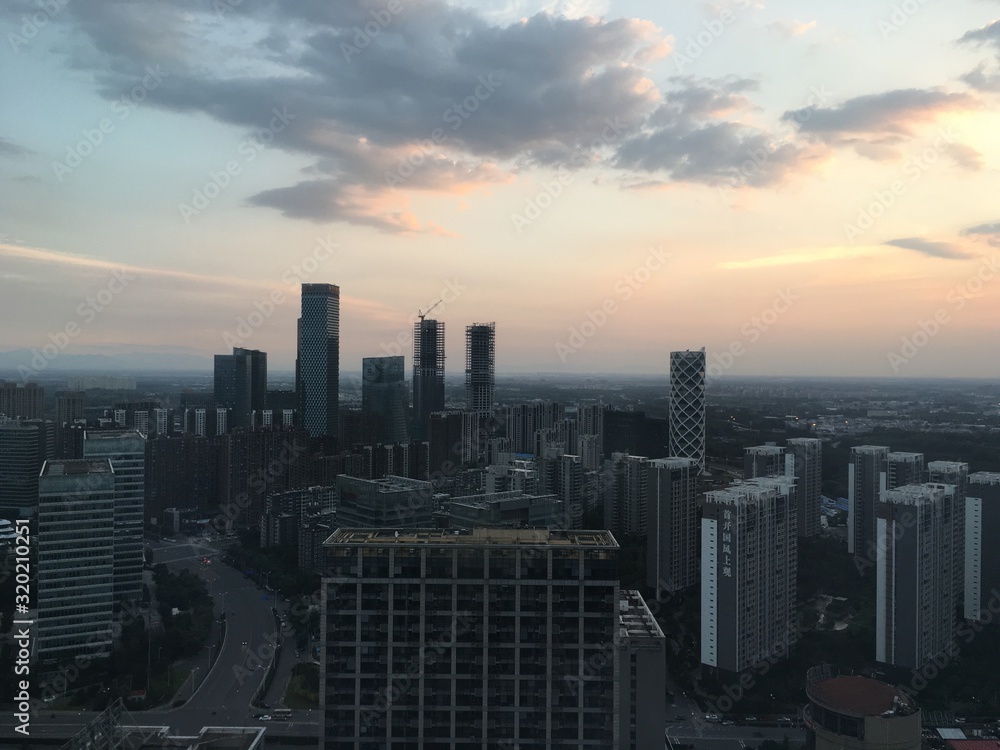 VIEW OF CITYSCAPE AGAINST CLOUDY SKY DURING SUNSET