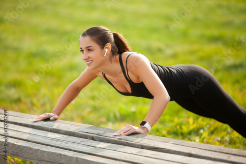 Portrait of beautiful sporty woman in sportswear doing push-ups © Maksymiv Iurii