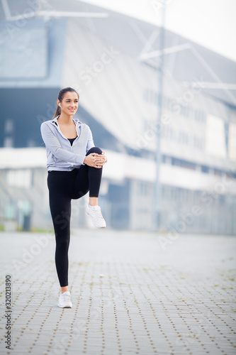 Fitness woman doing workout standing in a stadium background