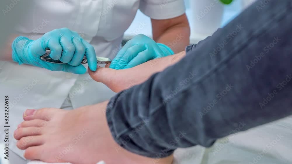 Pedicure specialist trims toenails of young male with nail nipper Stock ビデオ Adobe Stock