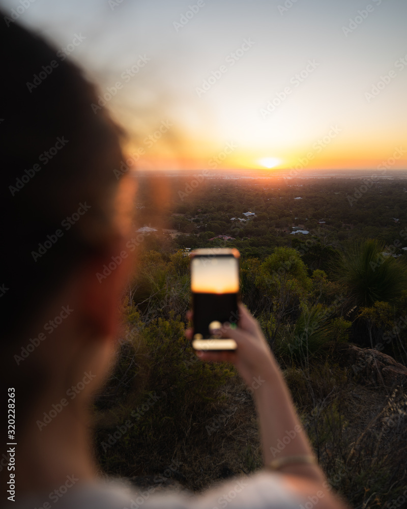 Fototapeta premium Taking picture of sunset with a mobile phone