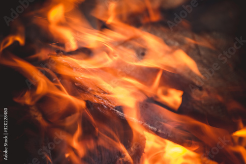 Firewood burning with bright flame in an iron brazier after an arson for frying meat kebabs.