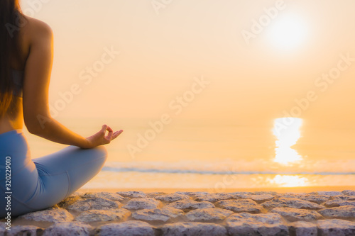 Portrait young asian woman do meditation around sea beach ocean at sunrise