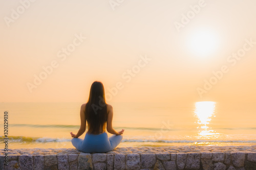 Portrait young asian woman do meditation around sea beach ocean at sunrise © siraphol