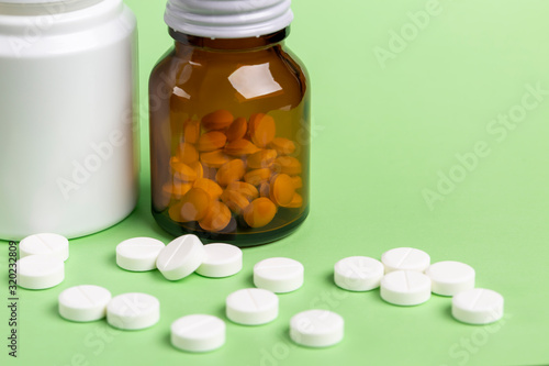 Glass and plastic drug bottles with white pills inside