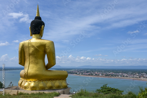 The big golden Buddha statue of Phu Salao temple with Mekong River flows through the Pakse city Laos