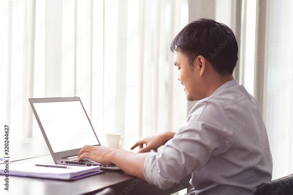 Office workers using laptops on the table with clipping path on white screen. Notebook with white screen on the wooden table in the office building at bangkok , Thailand. Office workers using laptops on the table with clipping path on white screen. Notebook with white screen on the wooden table in the office building at bangkok , Thailand.
