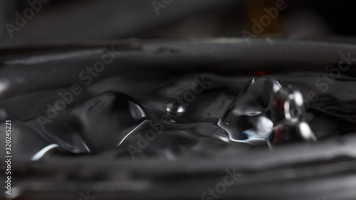 Abstract rippled background texture. Surface of water frozen in time, hi contrast lighting exposes the fascinating patterns created by soundwaves traveling directly through it. 