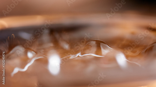 Abstract rippled background texture. Surface of water frozen in time, hi contrast lighting exposes the fascinating patterns created by soundwaves traveling directly through it. 