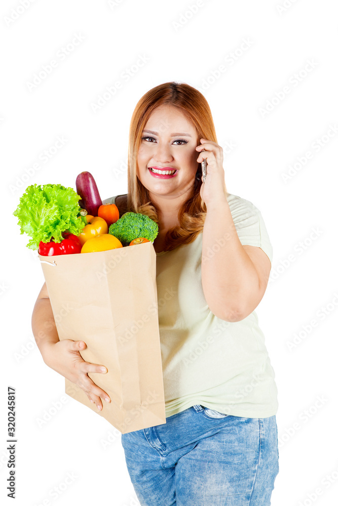 Overweight woman carrying paper bag with vegetable Overweight woman carrying paper bag with vegetable