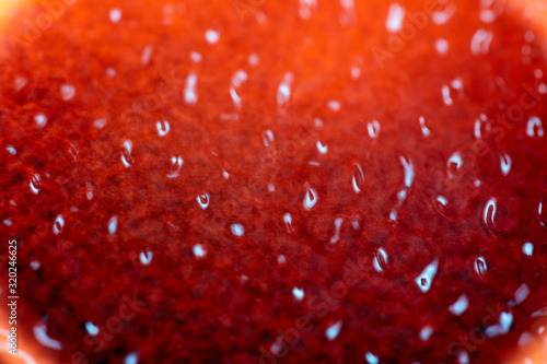 Shiny amber and black rippled background texture. Surface of water frozen in time, hi contrast lighting exposes the fascinating patterns created by soundwaves traveling directly through it. 